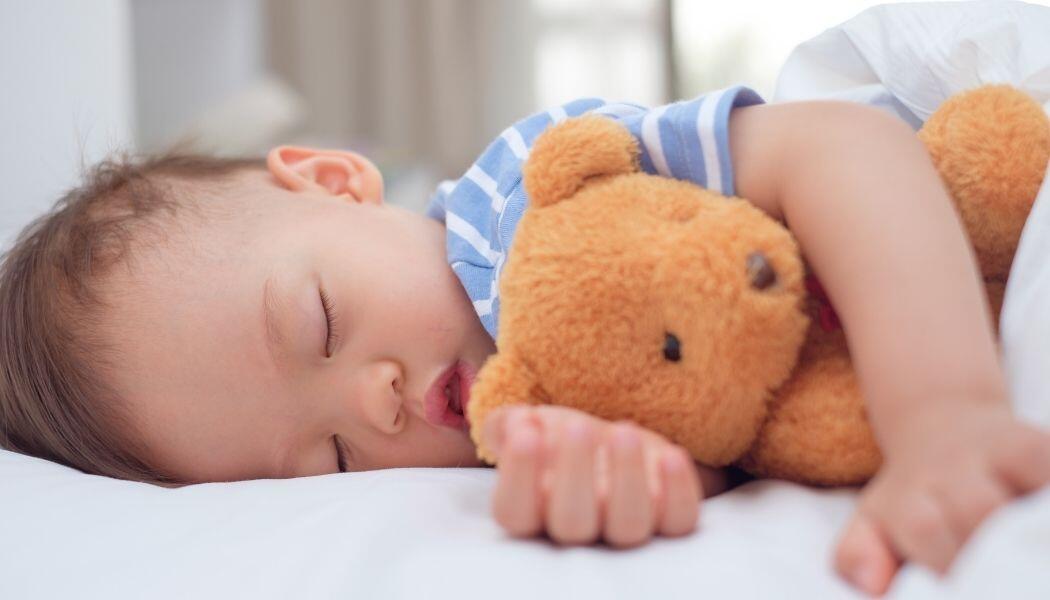 Baby schläft mit Kuscheltier