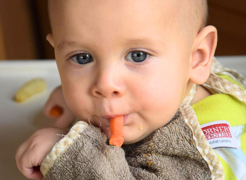Vor- und Nachteile von Baby-led Weaning: Baby versucht sich an Karottenstückchen
